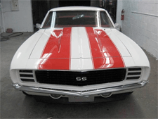 A white car with red and white stripes on the hood
