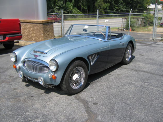A blue and black sports car is parked in a parking lot