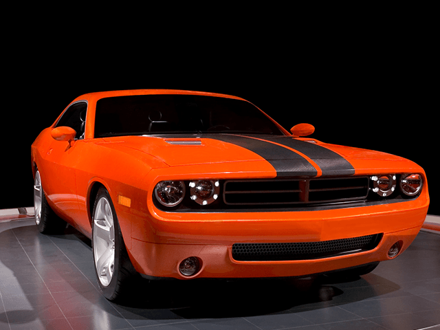 An orange dodge challenger with black stripes on the side
