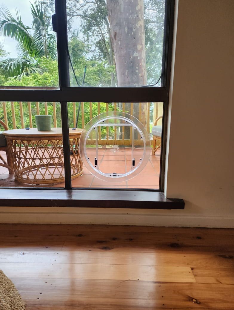 A Living Room With A Sliding Glass Door And A Cat Door — Lumba Glass & Glazing In Kincumber, NSW