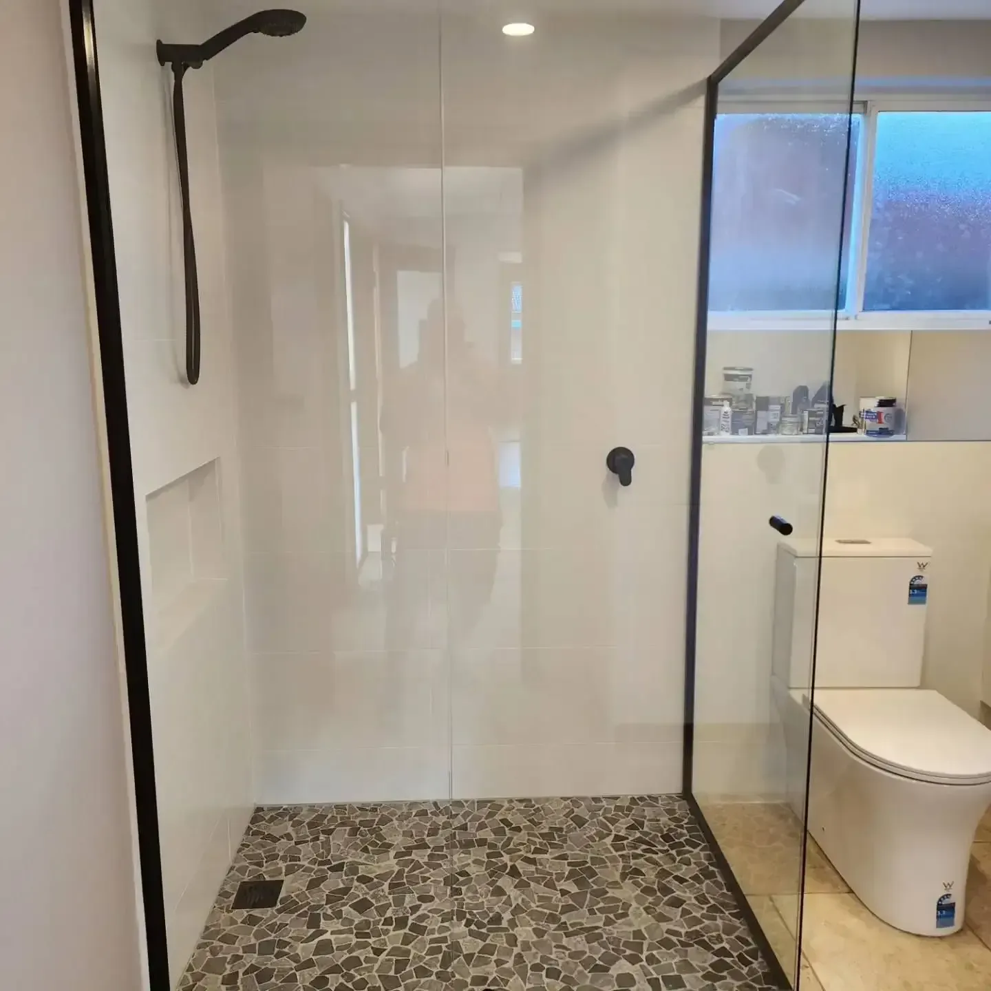 A Bathroom With A Toilet And A Walk In Shower With A Glass Door — Lumba Glass & Glazing In Kincumber, NSW