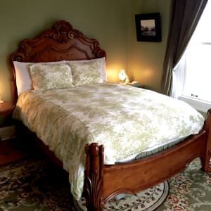A bed is sitting in a bedroom next to a window.