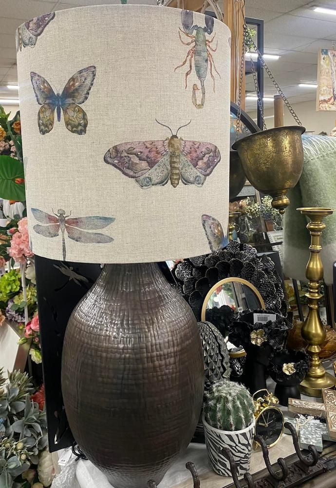 A Lamp With a Butterfly and Dragonfly Shade is Sitting on a Table — Tamworth Interiors in Scone, NSW
