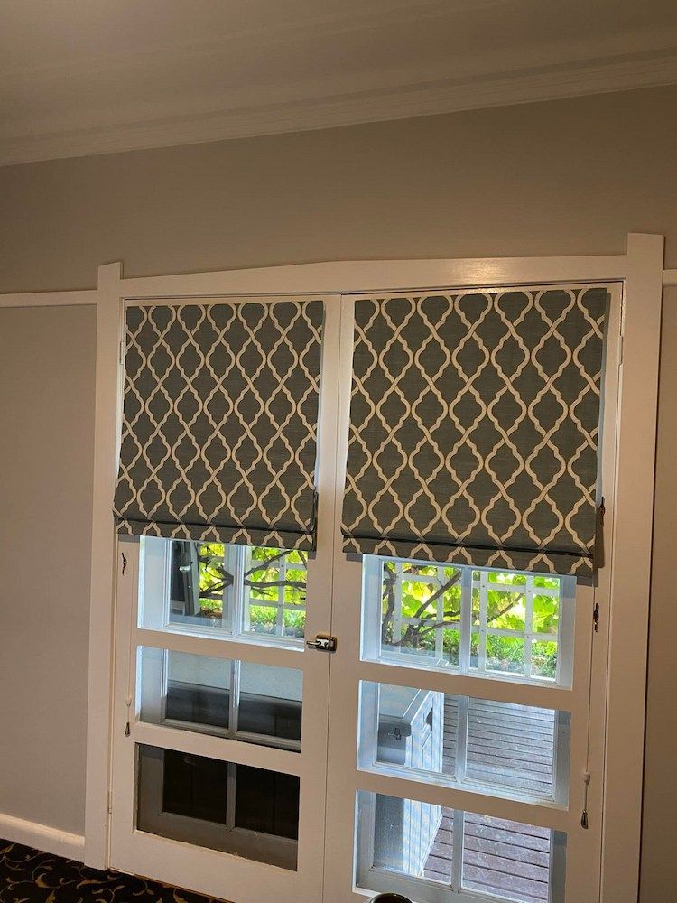 A Pair of Sliding Glass Doors With Roman Shades on Them — Tamworth Interiors in Narrabri, NSW