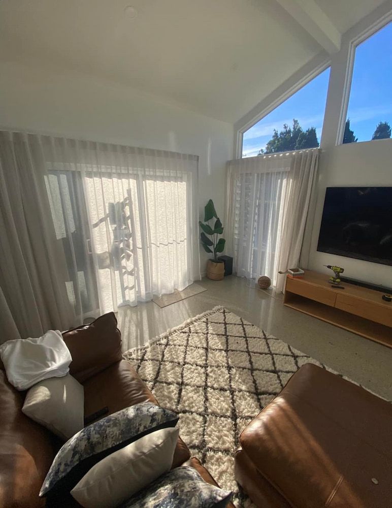 A Living Room With a Couch, Rug, Television and Sliding Glass Doors — Tamworth Interiors in Narrabri, NSW