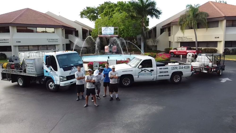 A group of men are standing in front of a row of trucks.