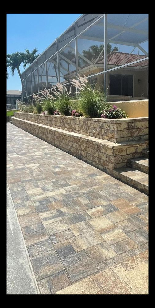 A brick walkway leading to a house with a screened in pool.