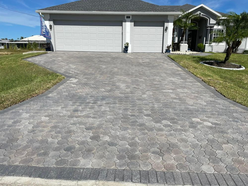 A driveway leading to a house with two garage doors