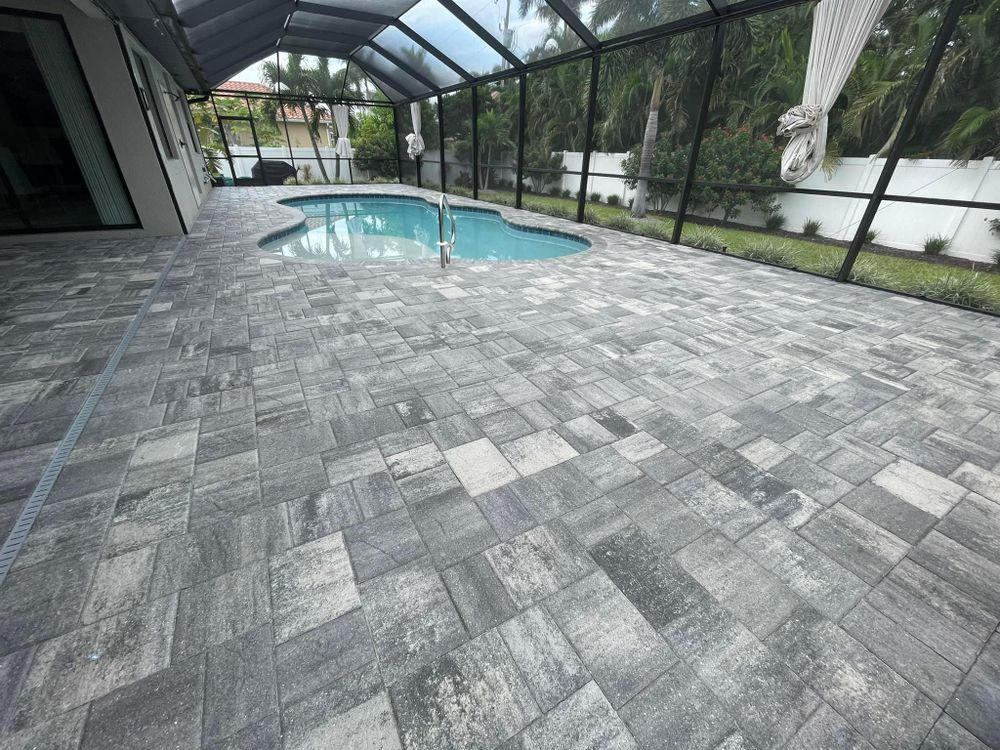 There is a swimming pool in the backyard with a screened in area.