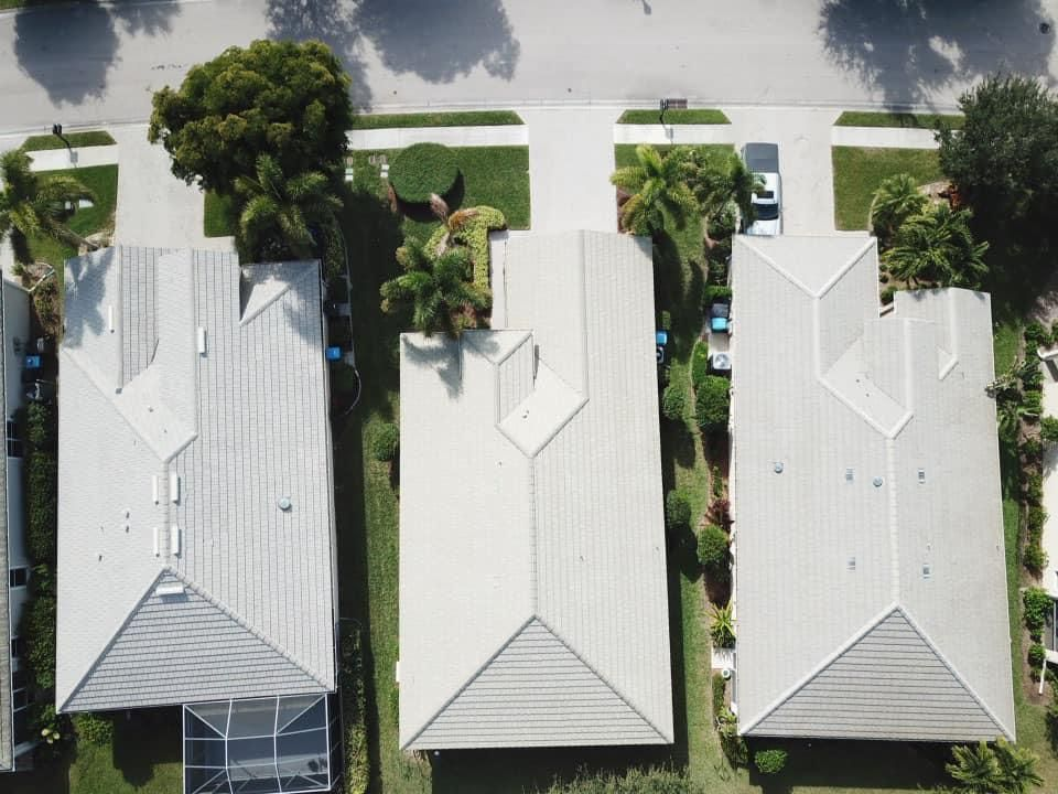 An aerial view of a row of houses with white roofs