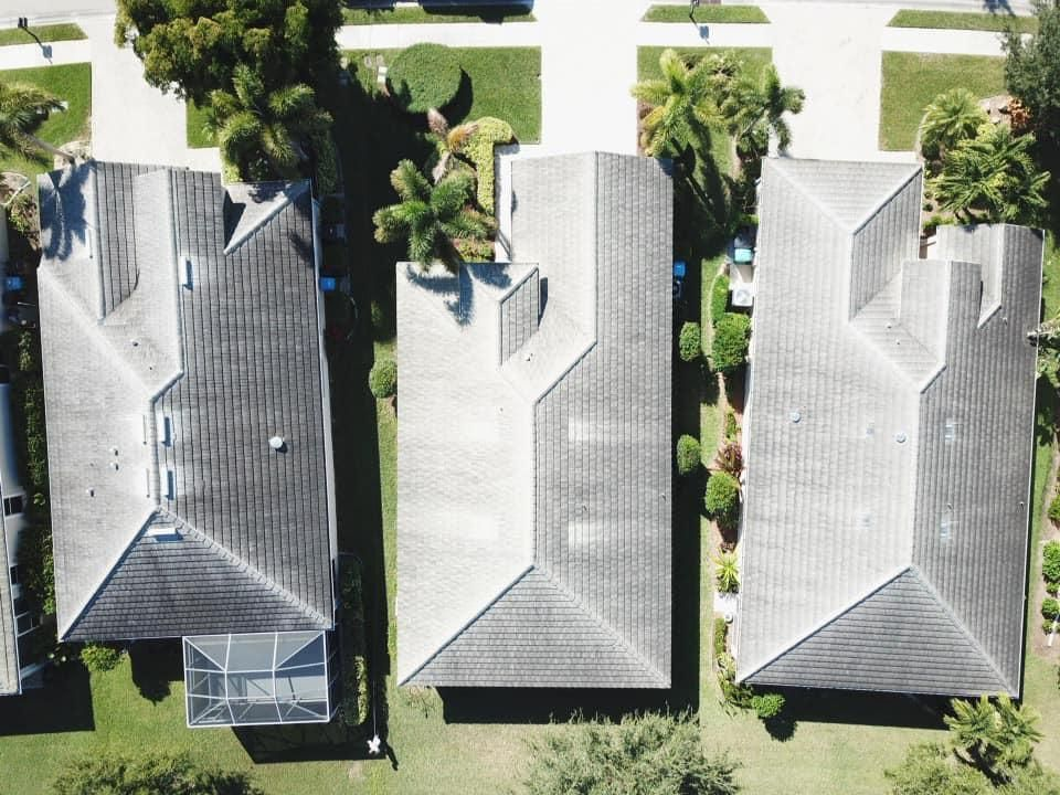 An aerial view of three houses in a residential area