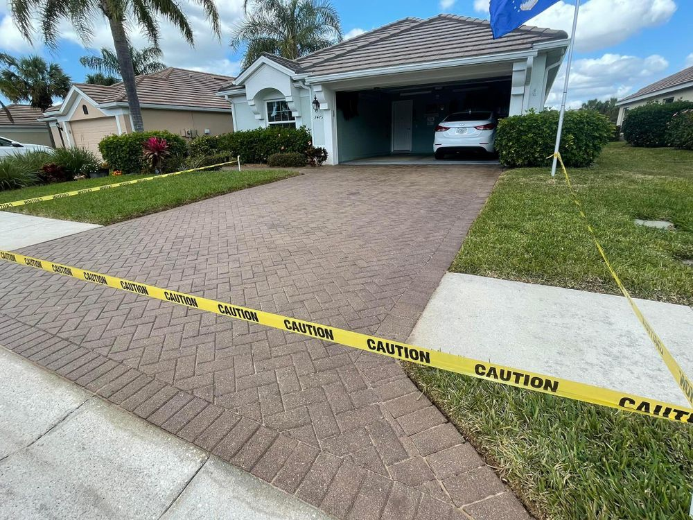 A car is parked in the driveway of a house behind a caution tape.