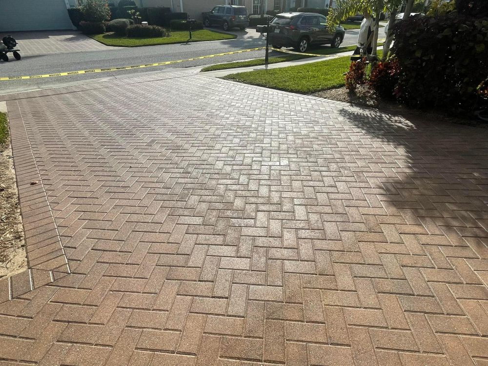A brick driveway with a car parked on the side of it.