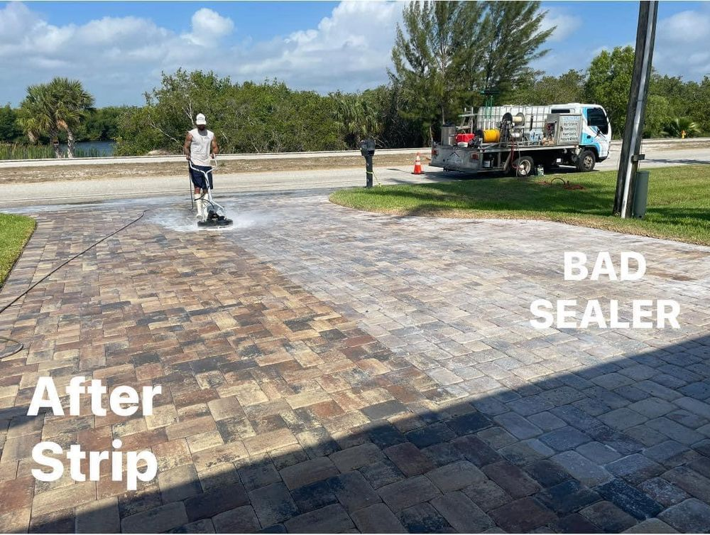 A man is cleaning a driveway with a machine.
