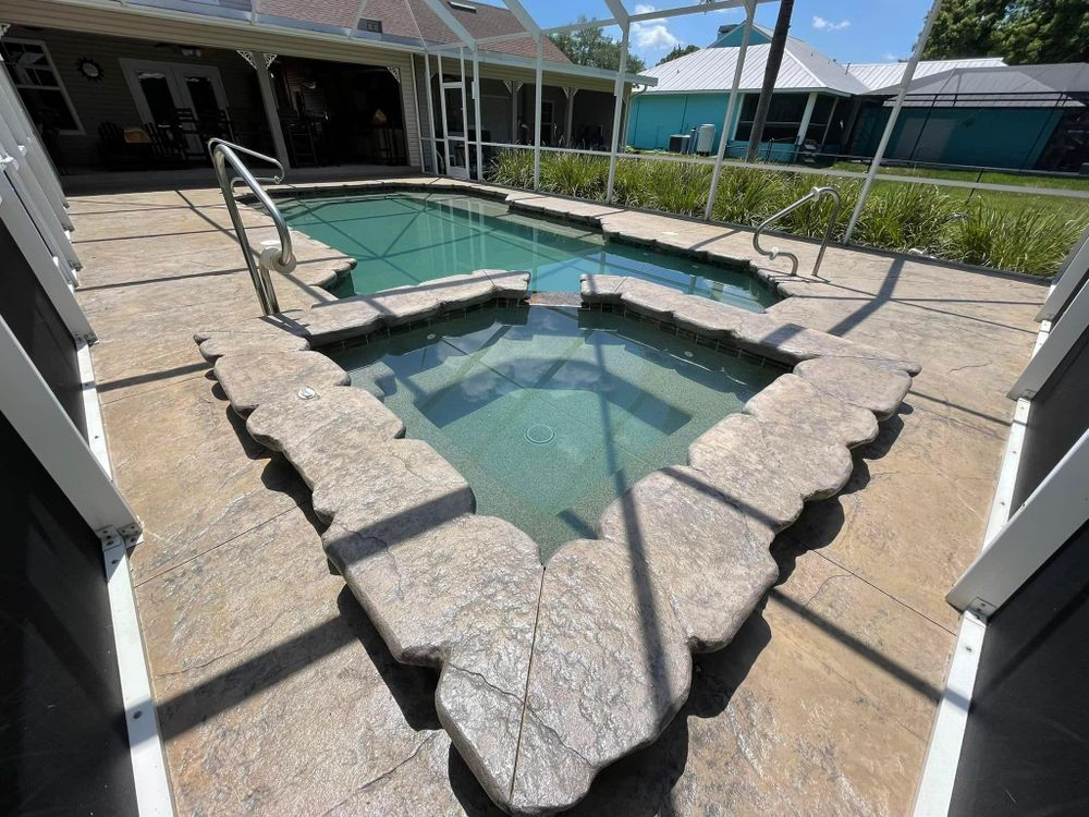 A swimming pool with a jacuzzi in the middle of it
