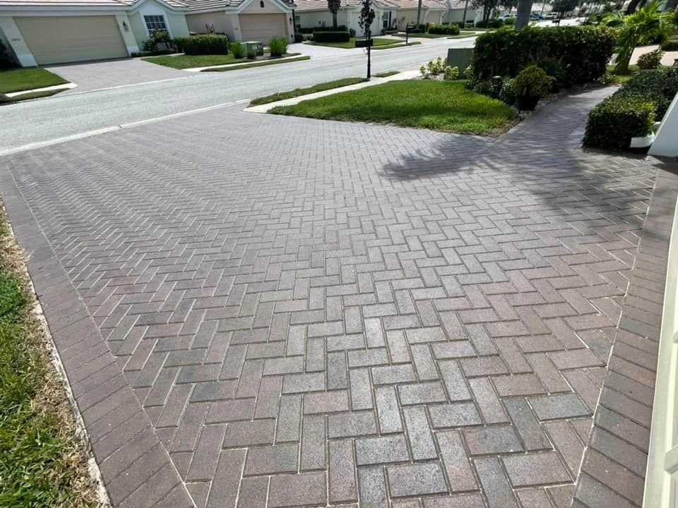 A brick driveway with a herringbone pattern in a residential area