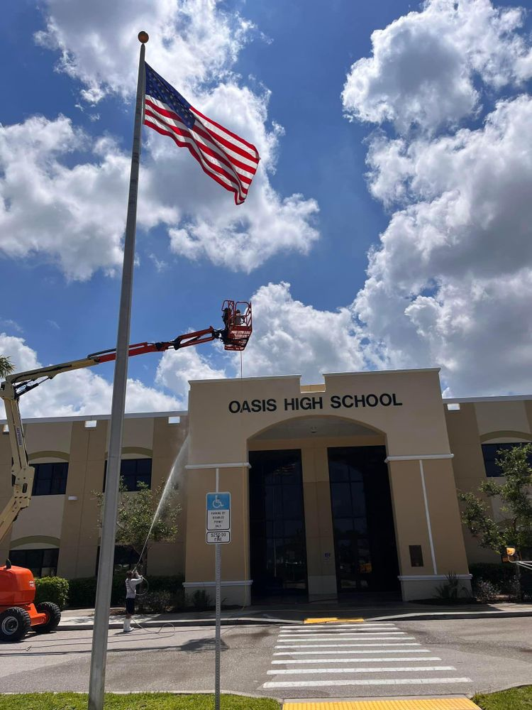 An american flag is being raised in front of oasis high school