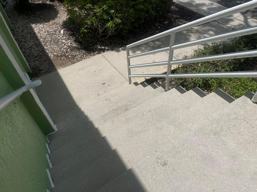 A set of stairs leading up to a green building with a metal railing.