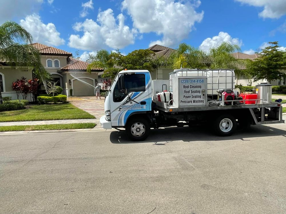 A white and blue truck is parked in front of a house.