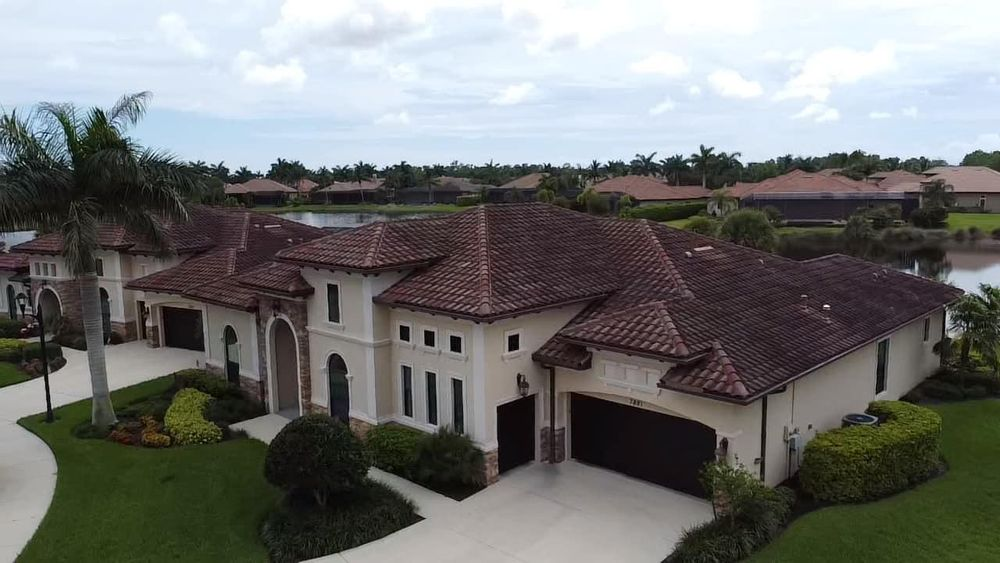 An aerial view of a large house with a red tile roof.