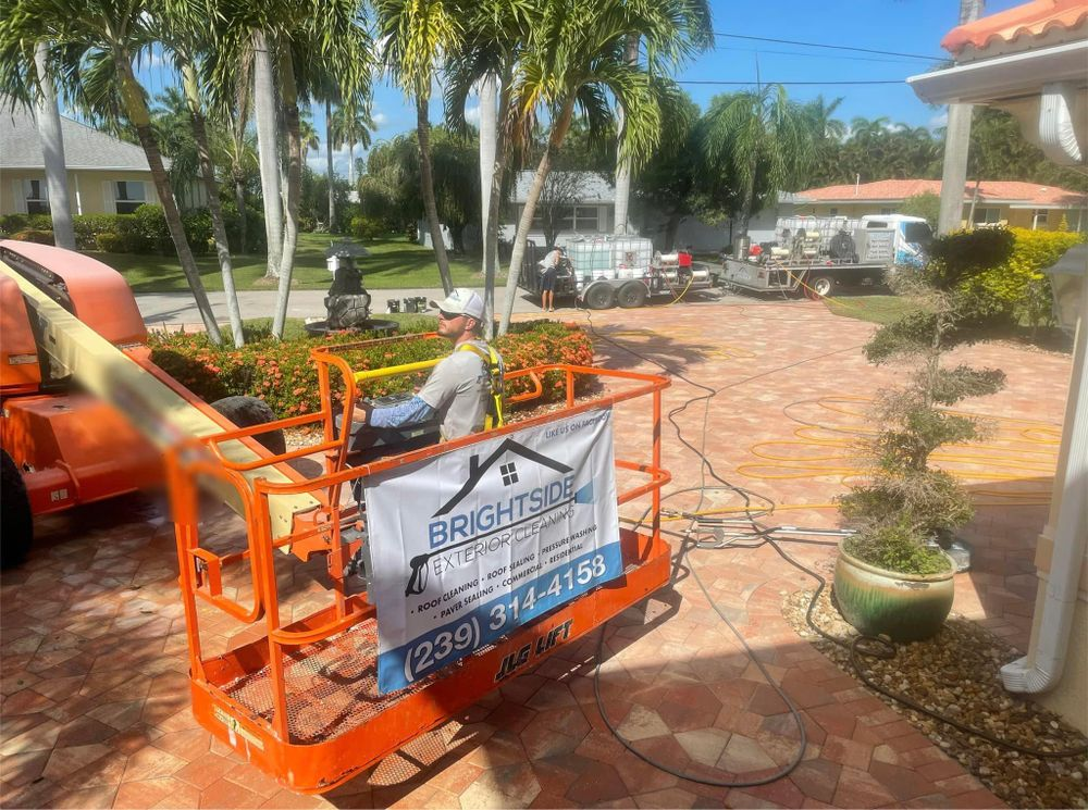 A crane with a sign on it is parked in front of a house.