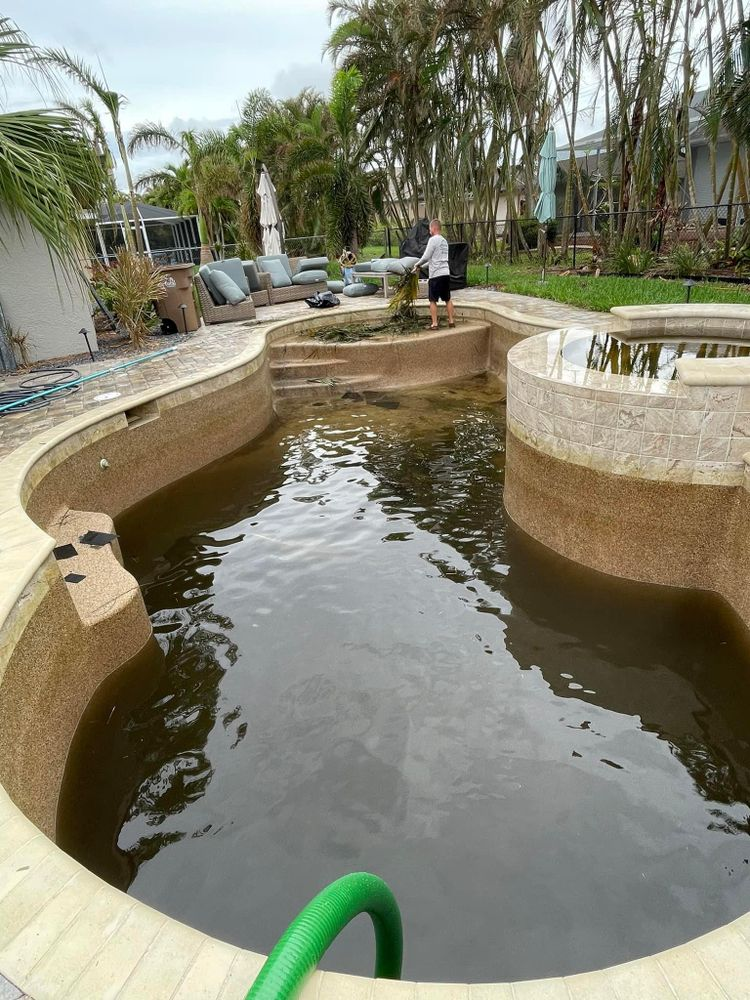 A man is standing in the middle of a swimming pool.