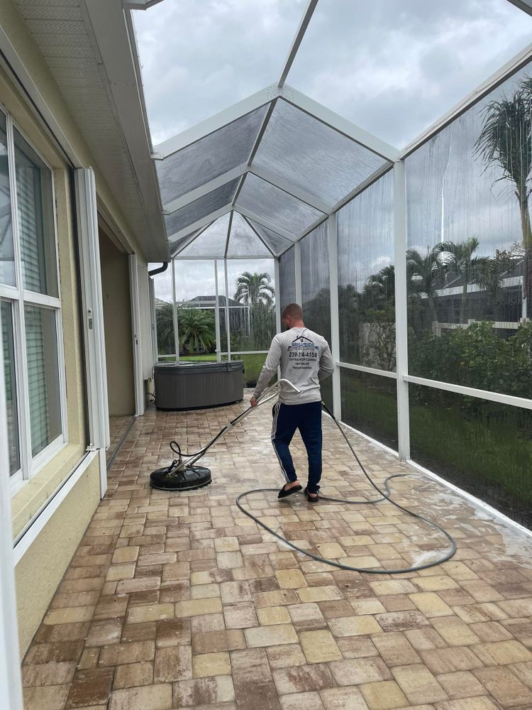 A man is cleaning a patio with a pressure washer.