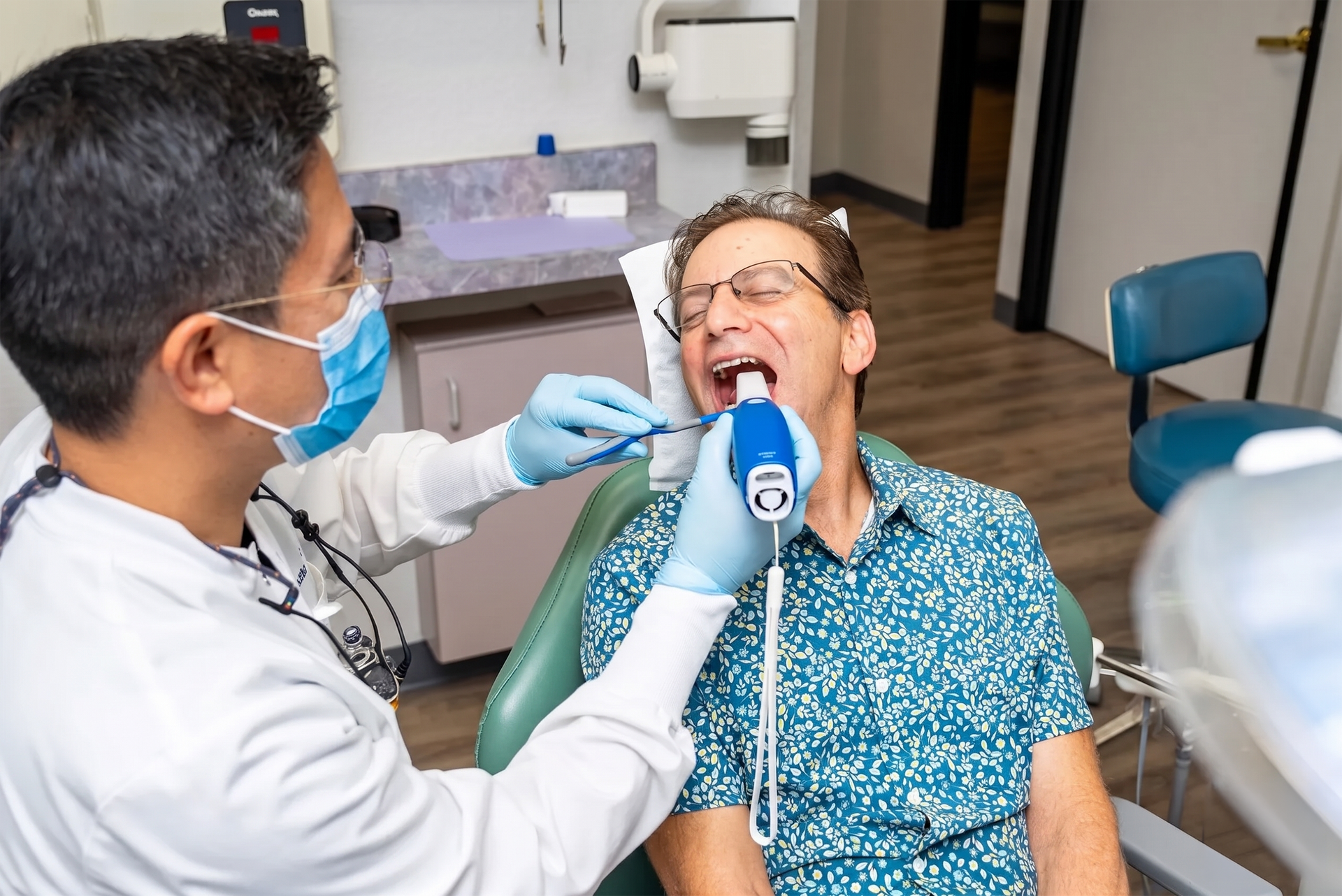 Dentist examining patient's mouth with tool in dental office.