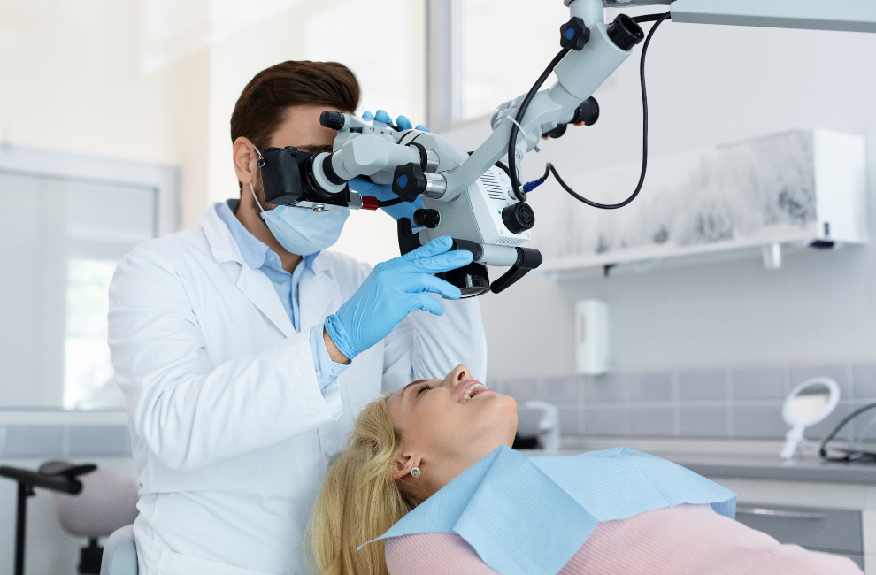 Dentist using a microscope on a patient in a dental office.