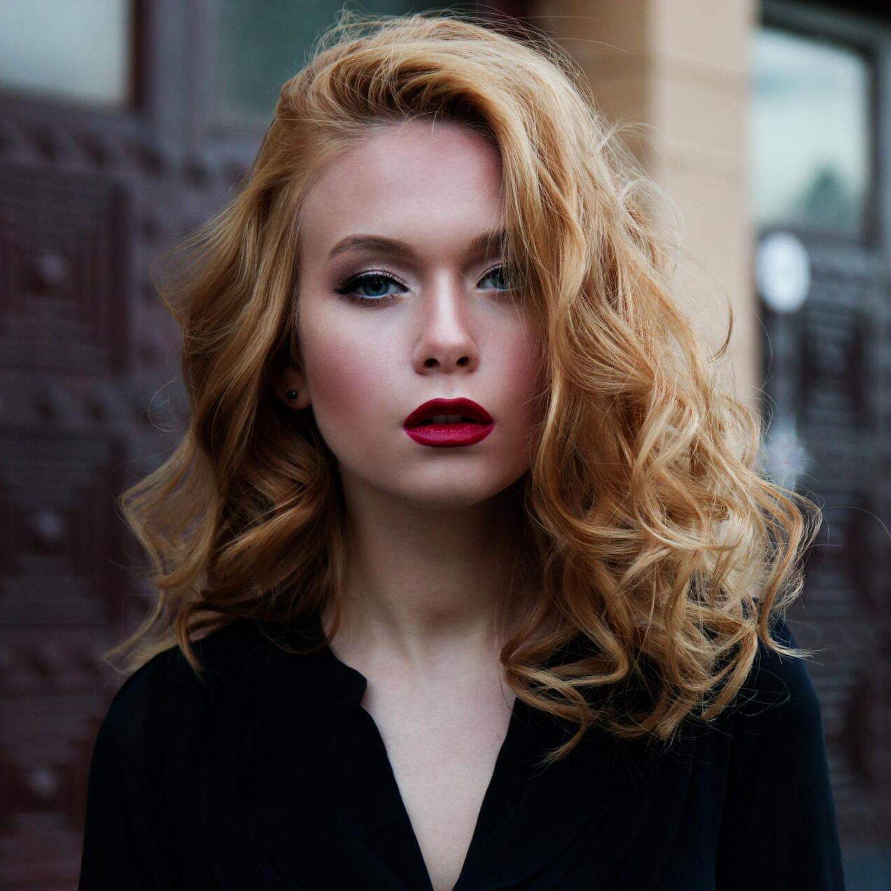 A woman with red lips is wearing a black shirt