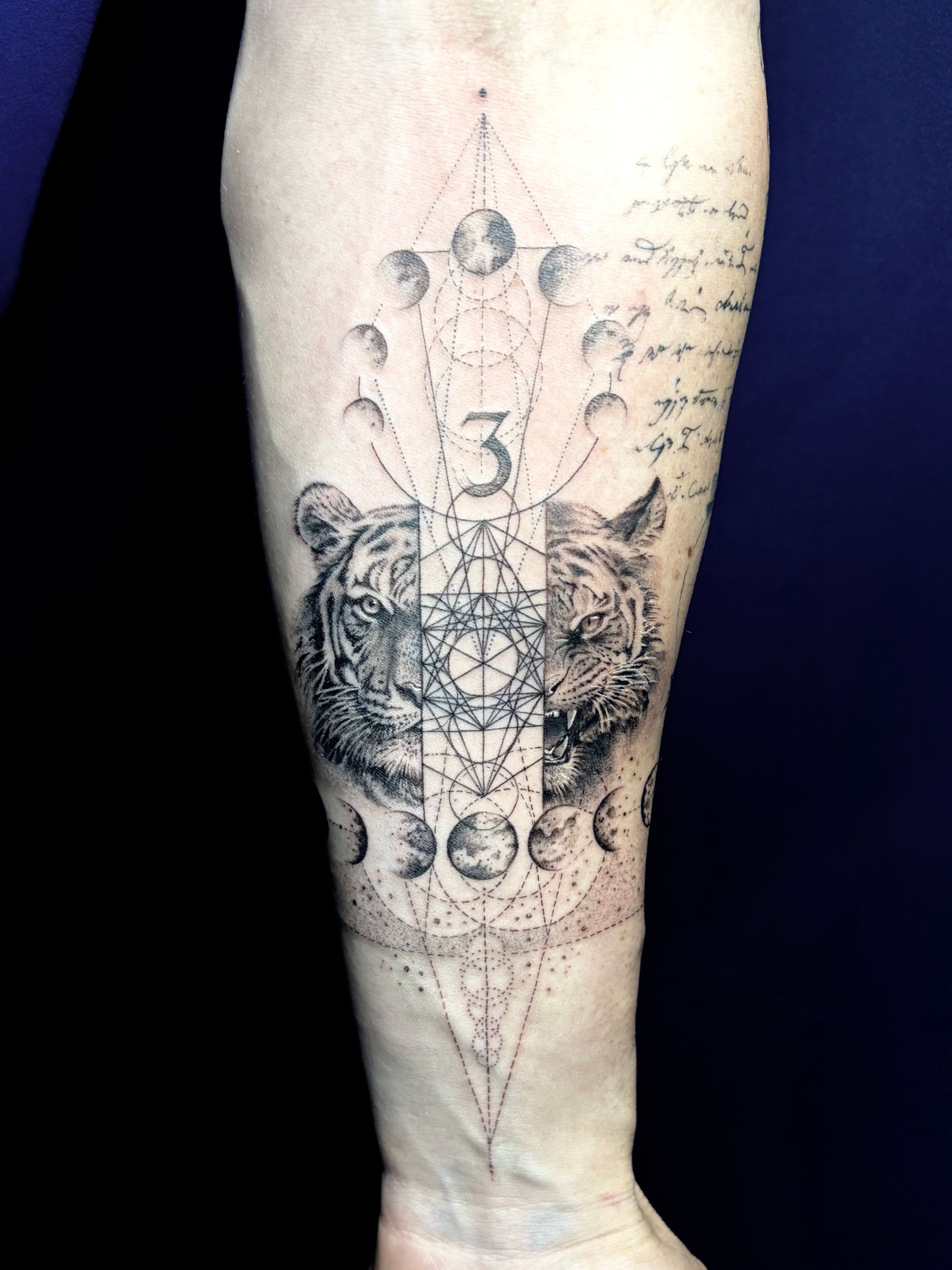 Geometric blackwork tattoo with a tiger, moon phases and sacred geometry