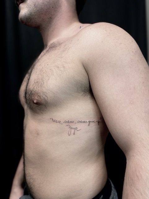Healed fine-line tattoo photographed on the upper back