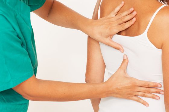 A woman is getting a massage from a doctor.