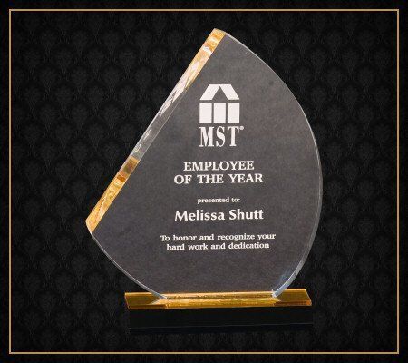 A glass plaque that says employee of the year on it