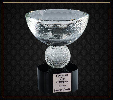 A glass trophy that says corporate cup champion on it