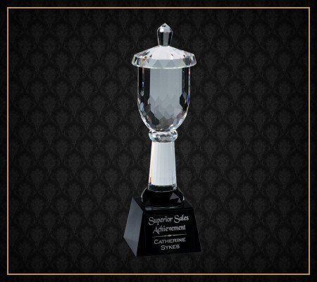 A glass trophy with a black base that says superior sales