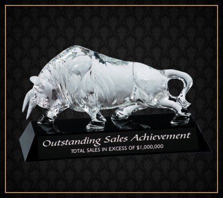 A glass statue of a bull on a black base that says outstanding sales achievement
