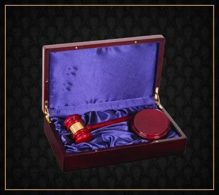 A wooden box with a red gavel inside of it