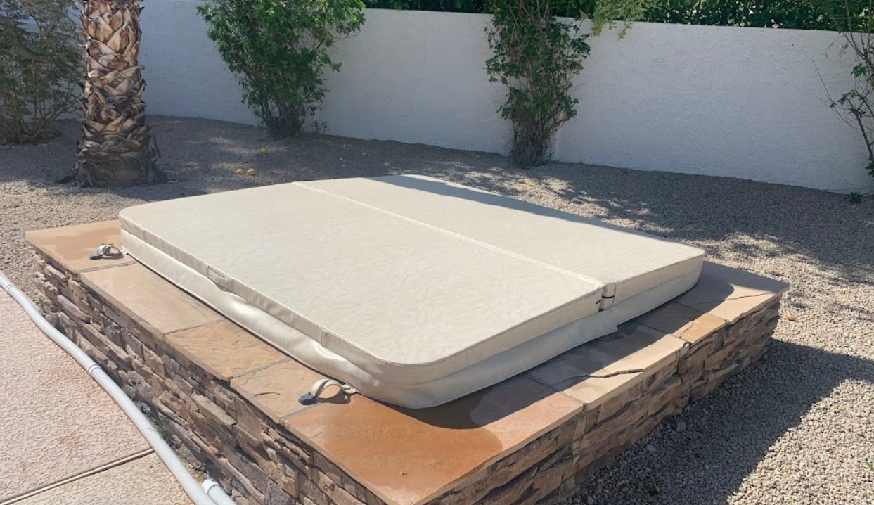 A hot tub is sitting on top of a brick wall.
