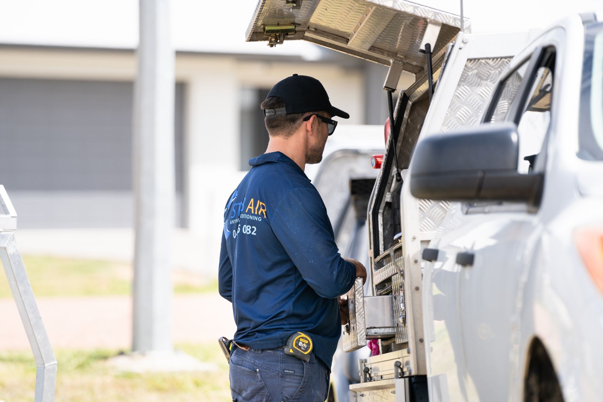 A Man in A Blue Shirt Is Pushing a White Truck — Staub Air in Garbutt, QLD