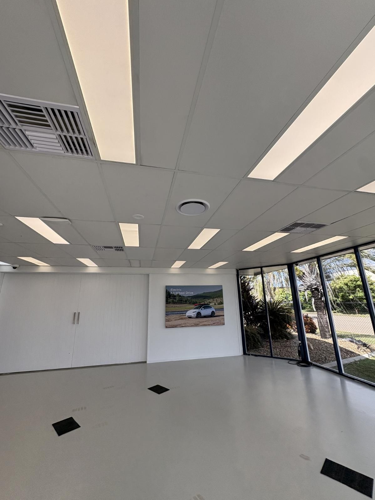 A Large Empty Room with A Painting on The Wall and A Lot of Windows — Staub Air in Garbutt, QLD