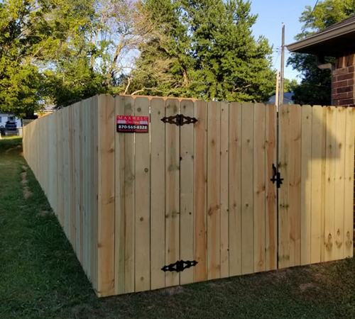 Wooden privacy fence around a yard with a locked gate and