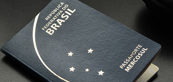 Passaporte brasileiro, capa azul-escura com letras prateadas, estrelas e linha curva.
