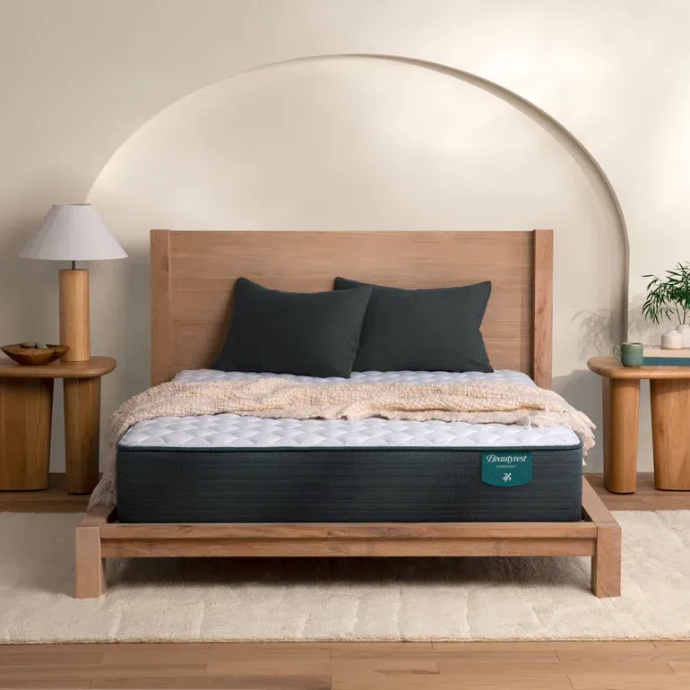 A bed with a mattress and pillows on it in a bedroom.