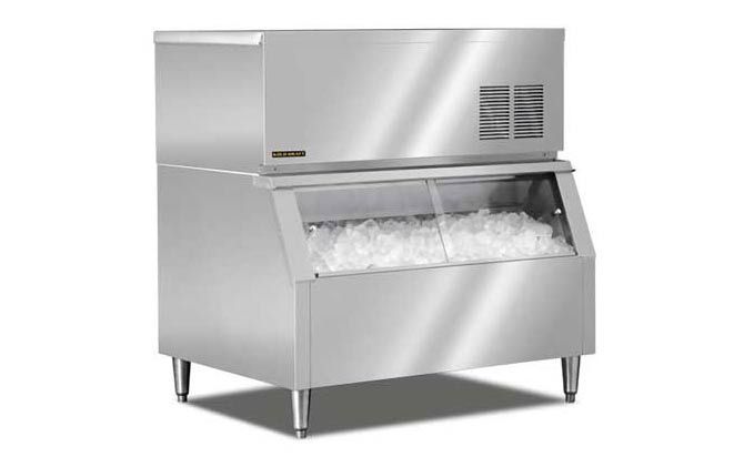 Stainless steel commercial ice machine dispensing ice, on white background