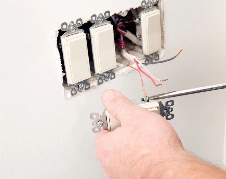 A person is fixing a light switch