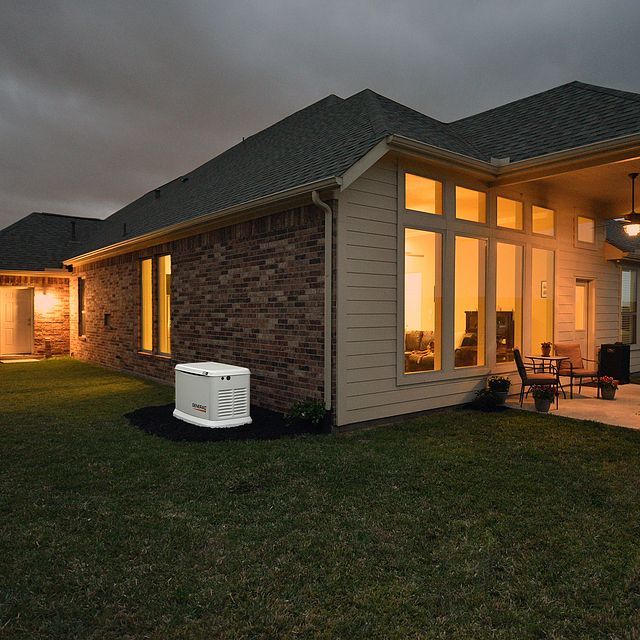 A house with a generator in the backyard at night