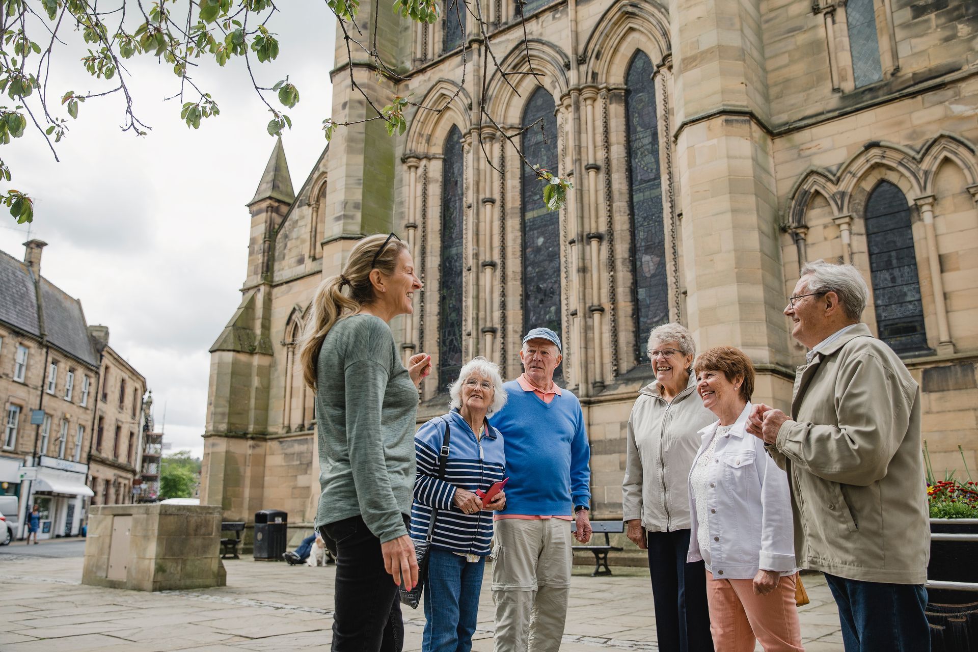 Group discussion outside historic cathedral building in North East England