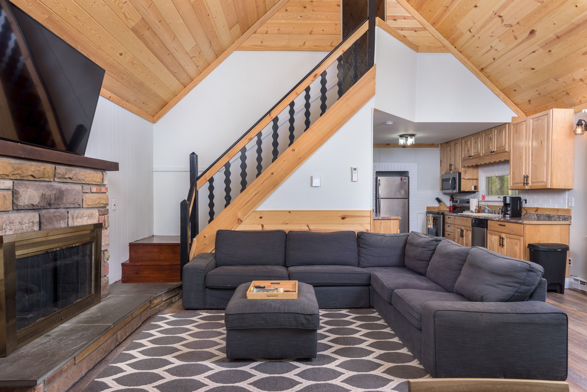 A living room with a couch , fireplace and stairs