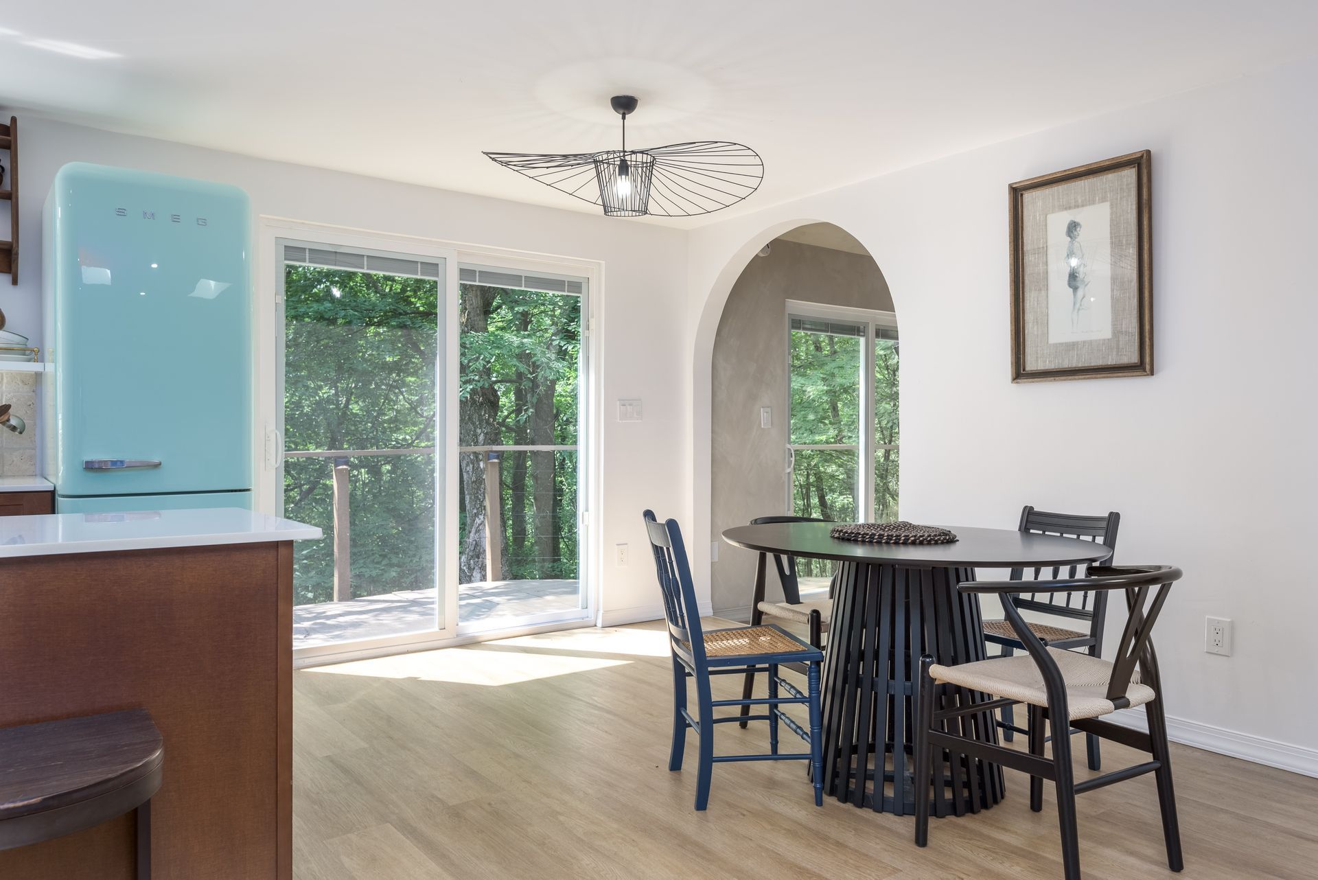 A kitchen with a table and chairs and a blue refrigerator.